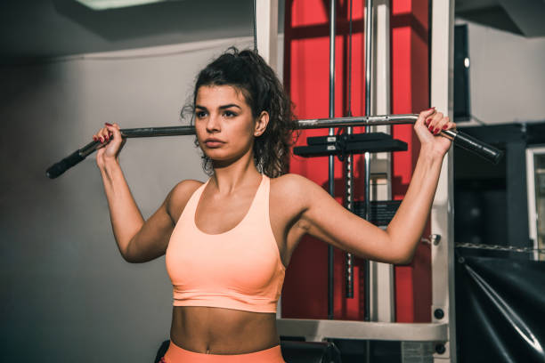 istock Sportswoman training on exercising gym equipment 882430832