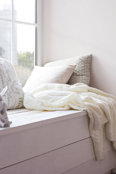 istock cushions and a knitted plaid on the windowsill. 882443992