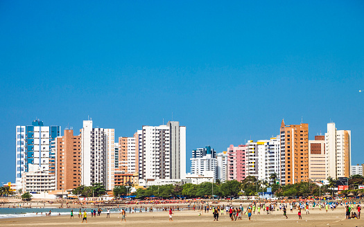 Popular public beach in town called Praia Ponta D'Areia is full of local people playing football, relaxing, sunbathing and swimming.