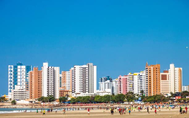 Brazilian beach scene, Sao luis Popular public beach in town called Praia Ponta D'Areia is full of local people playing football, relaxing, sunbathing and swimming. sao luis stock pictures, royalty-free photos & images