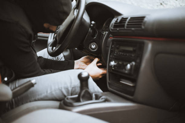 istock Thief trying to unmount plastic case below the steering wheel 882464152