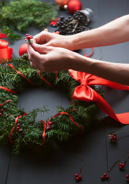 istock mom makes a Christmas wreath with her own hands 882468194