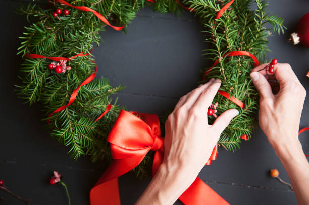 istock mom makes a Christmas wreath with her own hands 882468228