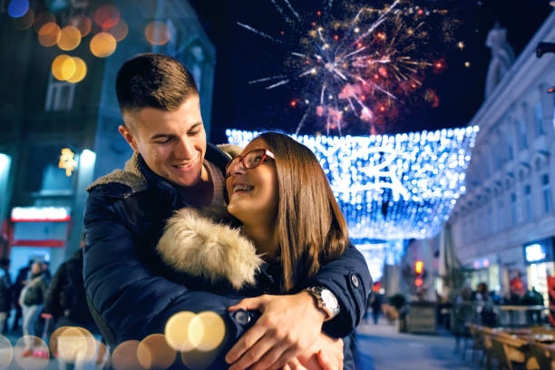istock Young romantic couple kissing below fireworks display in the sky 882487964