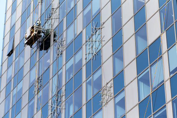 istock Mounting illuminating snow flakes on modern building with a help of construction cradle 882497658