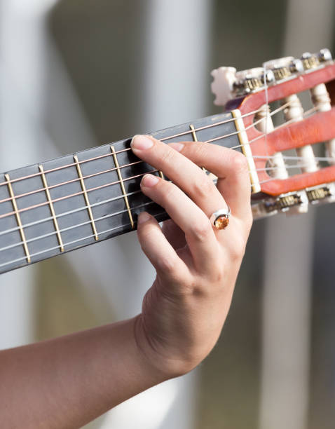 istock girl's hand playing guitar 882513058