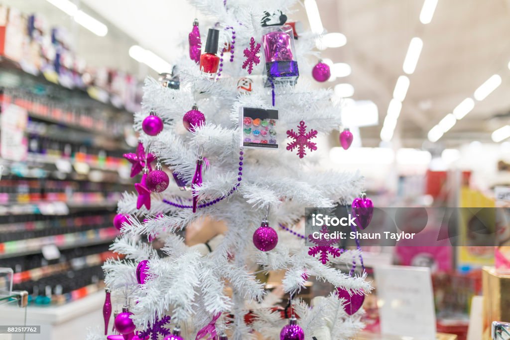 Foto de Roxo De Bugigangas E Compõem Pendurado Em Uma Árvore De Natal  Branca Na Montra De Uma Loja De Cosméticos Em Um Shopping No Reino Unido e  mais fotos de stock