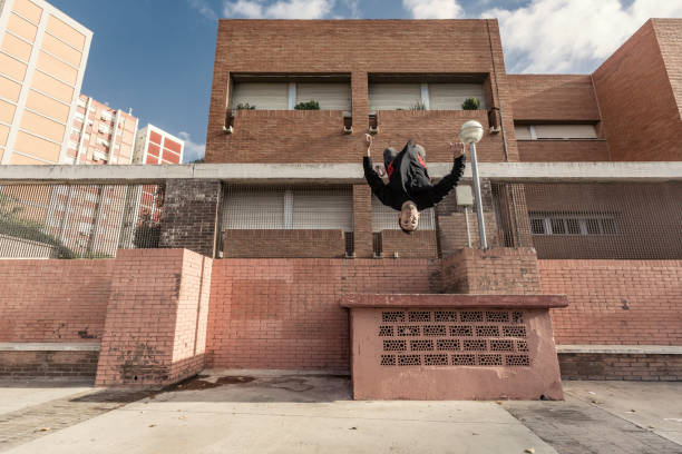 istock Man doing back flip practicing parkour in the city 882524322