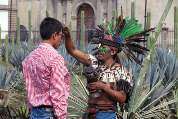 Mexico City, Mexico - October 31, 2017: A curandero, or Native American healer, treats a man for back pain just outside the Metropolitan Cathedral on the Plaza of the Constitution, or Zocalo. Belief in native tribal medicine, and spirituality, remains strong in Mexico.