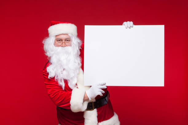 istock Santa Claus pointing in blank advertisement banner isolated on red background with copy space 882535068
