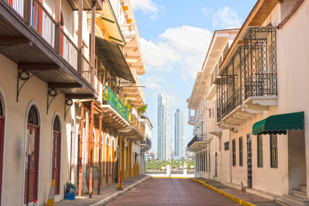 Casco Viejo street in an old part of Panama City Casco Viejo street in an old part of Panama City with deserted street early in the morning, in background distant skyscrapers of the new Panama city against blue sky. panama city panama photos stock pictures, royalty-free photos & images