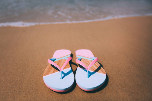 istock Trendy slippers on the sandy beach. 882547450