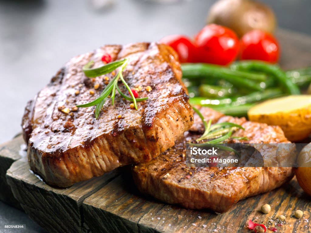 grilled beef steaks grilled beef steaks on wooden cutting board Steak Stock Photo