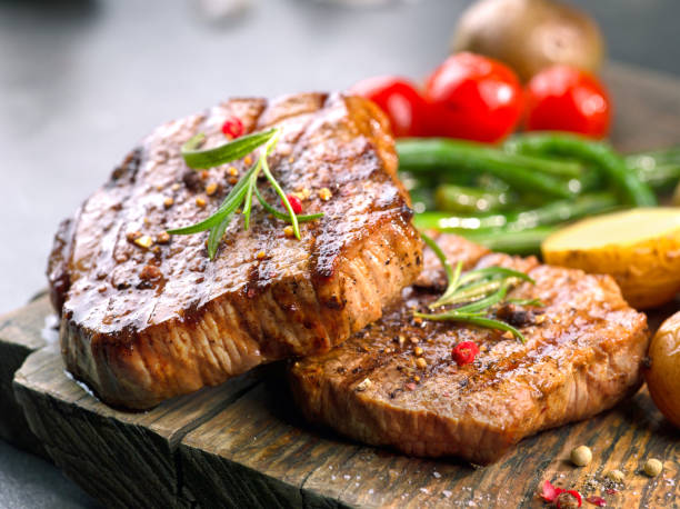 grilled beef steaks grilled beef steaks on wooden cutting board steak stock pictures, royalty-free photos & images