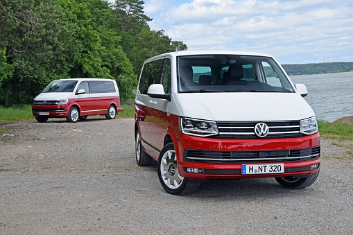 Scania, Sweden - June 25th, 2015: Volkswagen T6 Multivan vehicles parked on the road near the lake. Volkswagen T6 is powered by the 2.0-litre diesel engine or 2.0-litre petrol engine. This car is one of the most popular commercial vehicles in Europe.