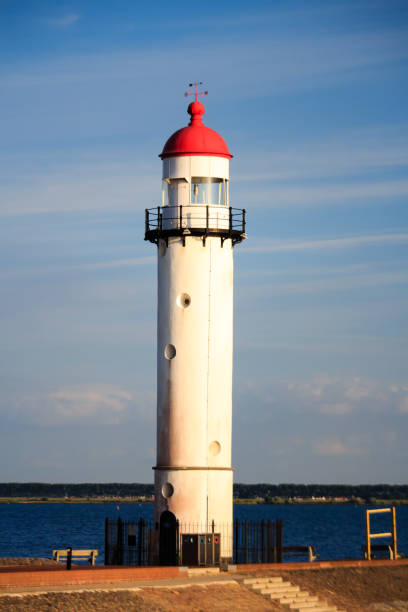 istock Red and white lighthouse in front of blue sky during the sunset 882584482