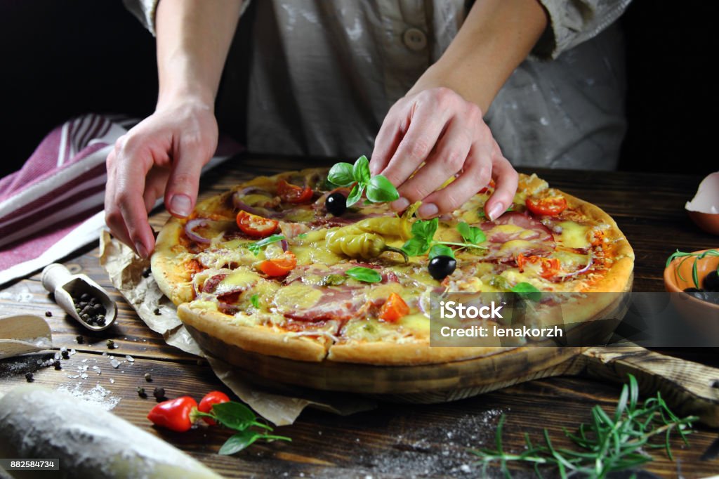 pizza with ham and basil a girl cooks pizza with tomatoes, ham and basil Adult Stock Photo