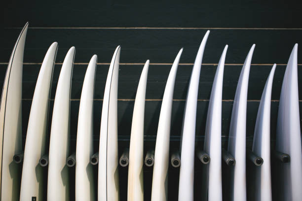 Set of different new white surf boards in a stack.