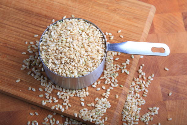 Closeup brown rice in a measuring cup Closeup brown rice in a measuring cup Cup of Brown Rice stock pictures, royalty-free photos & images