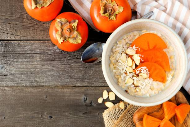 istock Breakfast oatmeal with persimmons overhead on wood 882625720