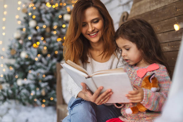 istock Mother and daughter reading on Christmas eve 882626172