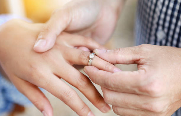 istock Groom wears ring on bride's finger. Selective focus at wedding ring. 882633420