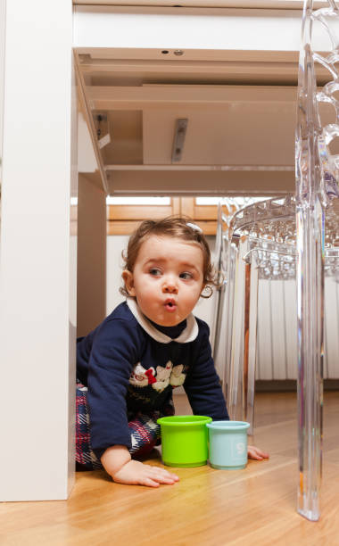 istock Toddler baby girl playing under the table 882649190