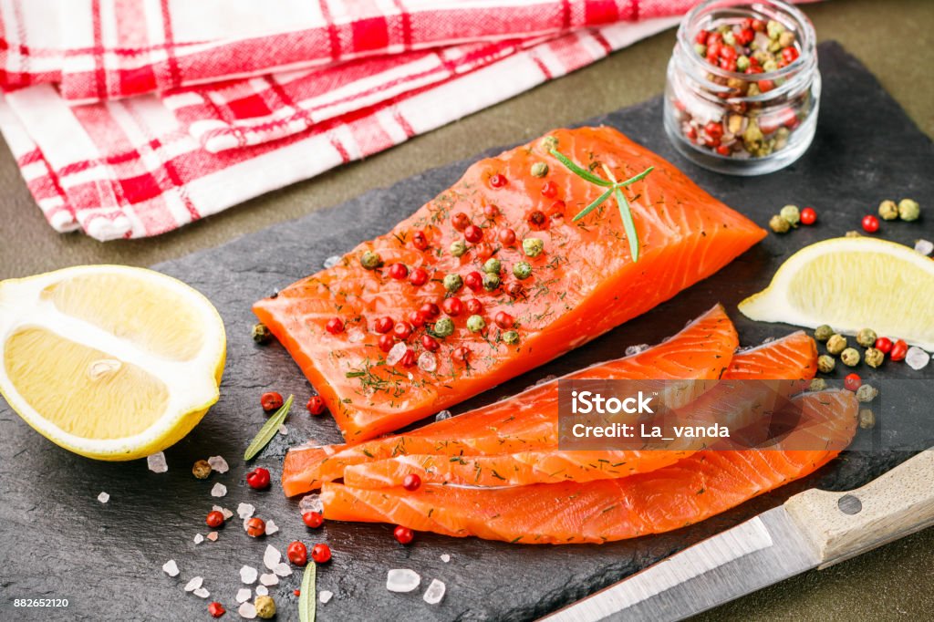 Gourmet Sliced salted salmon with pink and green peppercorn, lemon and dill. Fish. Seafood. Snack for gourmets. Selective focus Acid Stock Photo