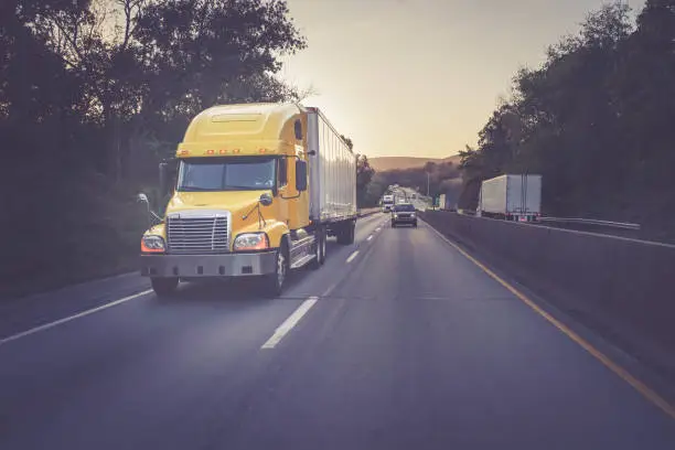 Semi truck 18 wheeler on highway with matte color treatment yellow sleeper tractor