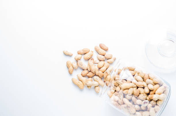 istock Peanuts in a jar  on white background. Flat lay and top view 882669672