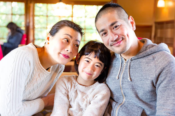 istock Asian family having fun time in cafe 882670598