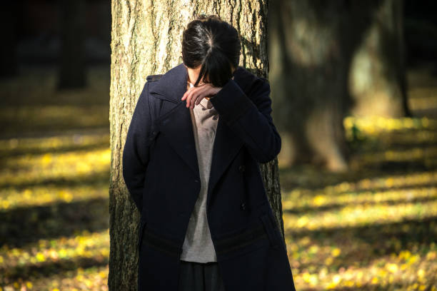 istock Depressed woman leaning on the tree 882693546