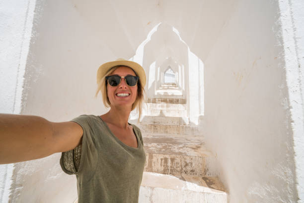 istock Young woman taking selfie in white temple, Myanmar 882695680