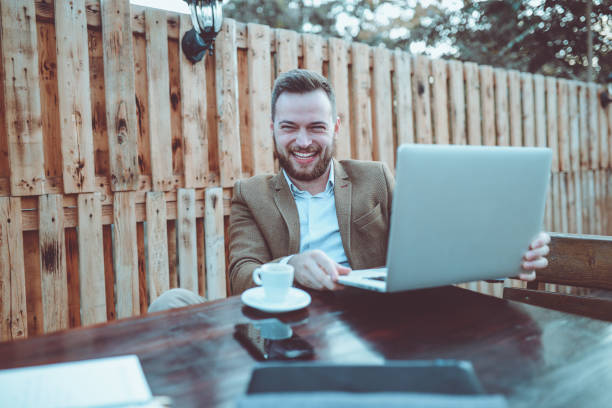 istock Young Smiling Businessman Working on Balcony and Drinking Cafe 882695794