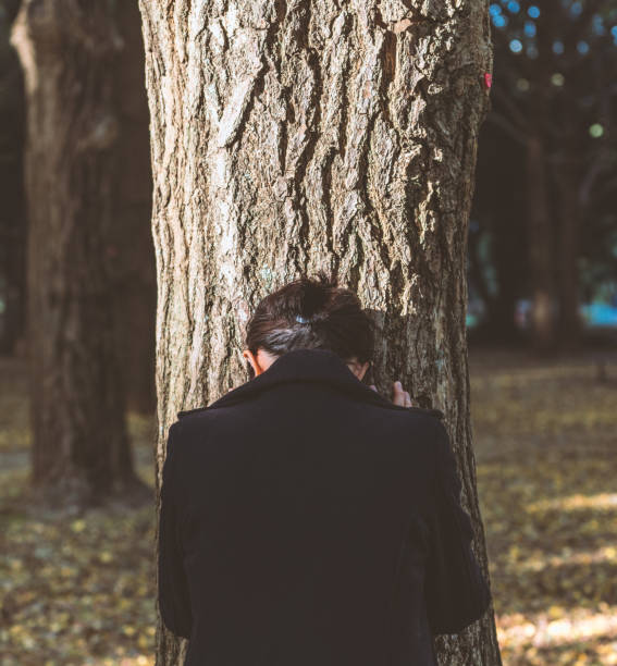 istock Depressed woman leaning on the tree 882698814