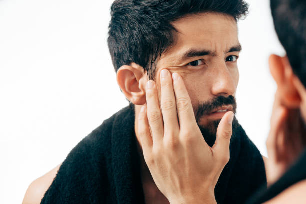 istock Man in front of mirrror looking at his wrinkles 882698842