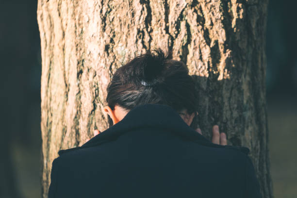 istock Depressed woman leaning on the tree 882701054