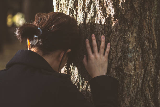 Depressed woman leaning on the tree