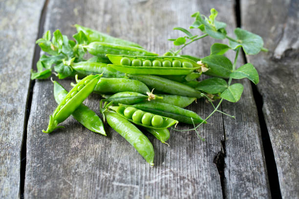 istock pea pods on wooden table 882731554