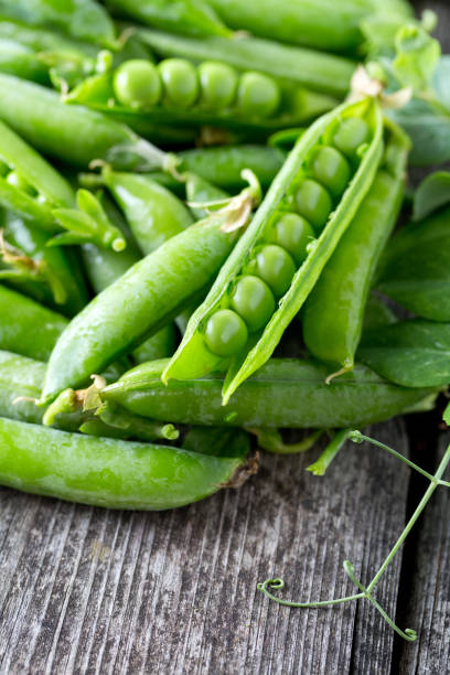 istock pea pods on wooden table 882731584