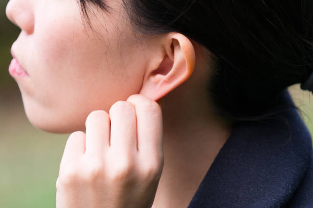 женщина с массажем уха - ear canal стоковые фото и изображения