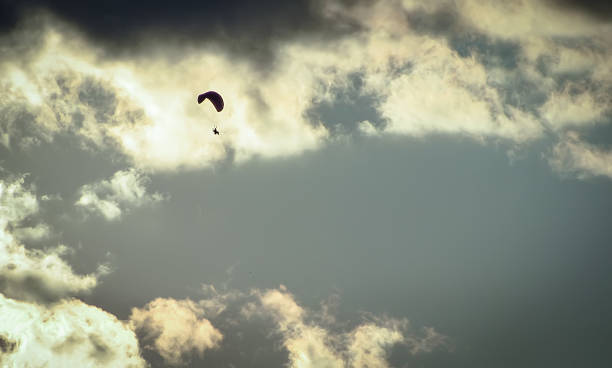 istock Freedom Paragliding, Man Flying Through Clouds on Sunset 882739778