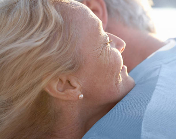 mature woman embracing man - ogen dicht closeup vrouw 50 jaar stockfoto's en -beelden