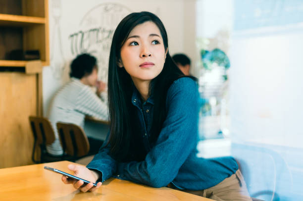 Woman using smart phone at cafe
