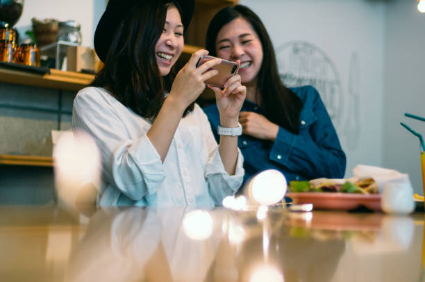 Laughing two young woman looking at smartphone