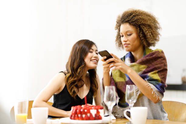 istock Two Young Women Using Phone On Birthday 882747680