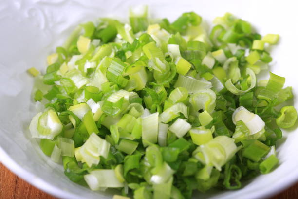 istock Chopped green onions in a white bowl 882747838