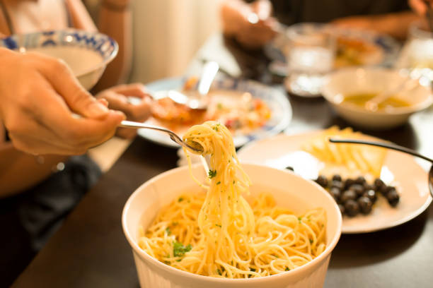 Close up of unrecognizable person eating pasta for dinner.