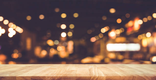 istock Wood table with blur light bokeh in dark night cafe 882789158
