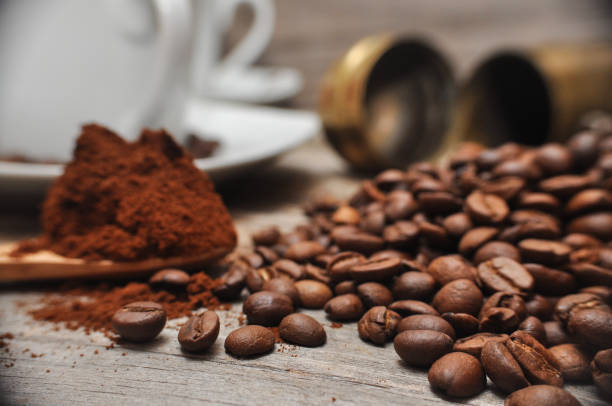 istock Milled coffee and coffee beans on old wooden background 882789254